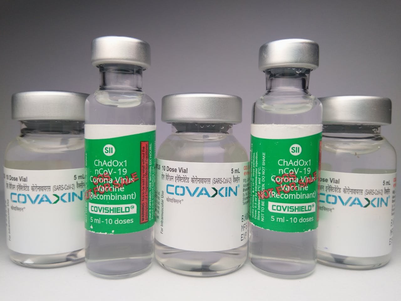 Close-up of Covaxin and Covishield vaccine vials for COVID-19 healthcare use.